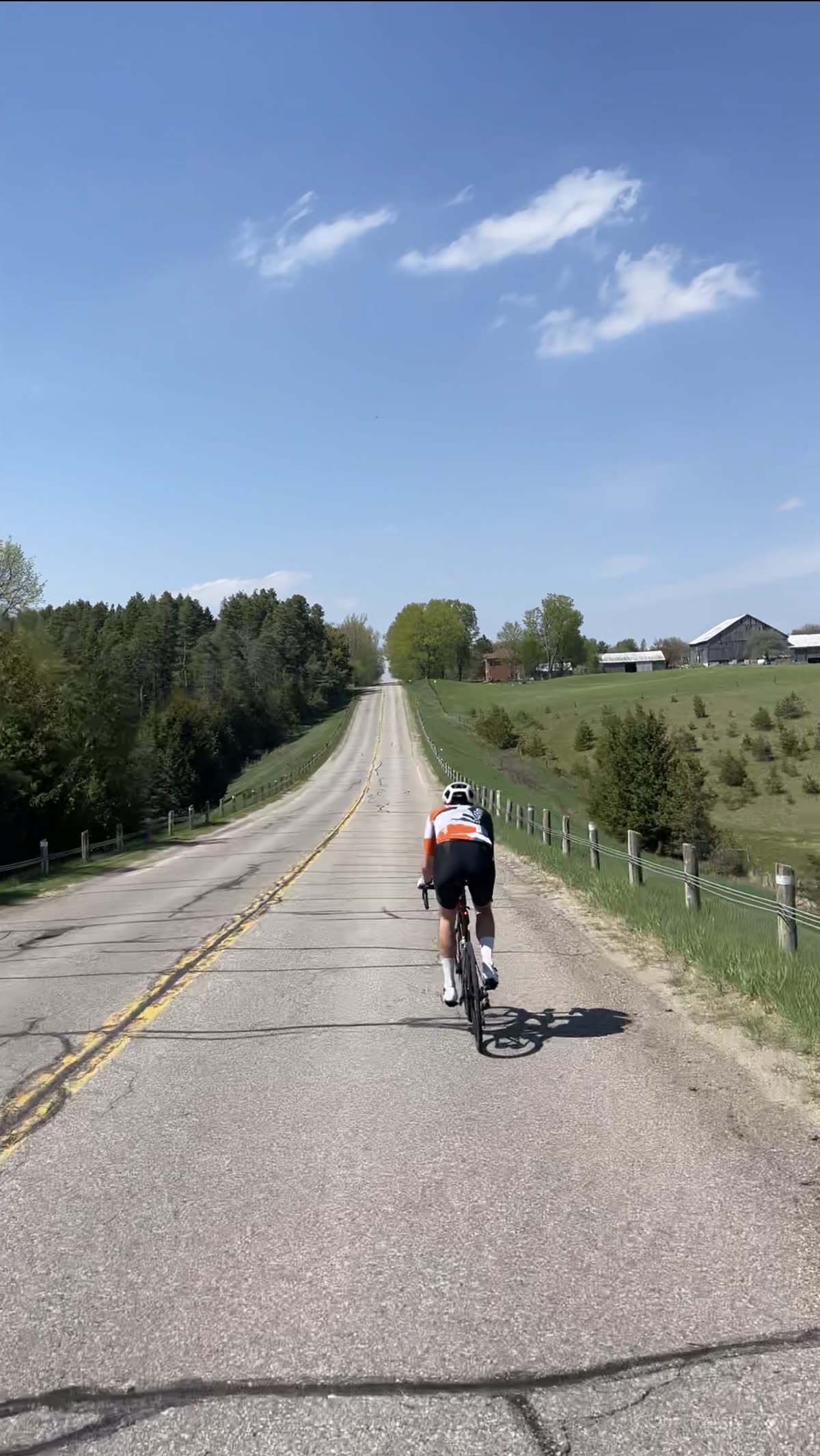 Cyclist climbing a rolling country road in the Hockley Valley
