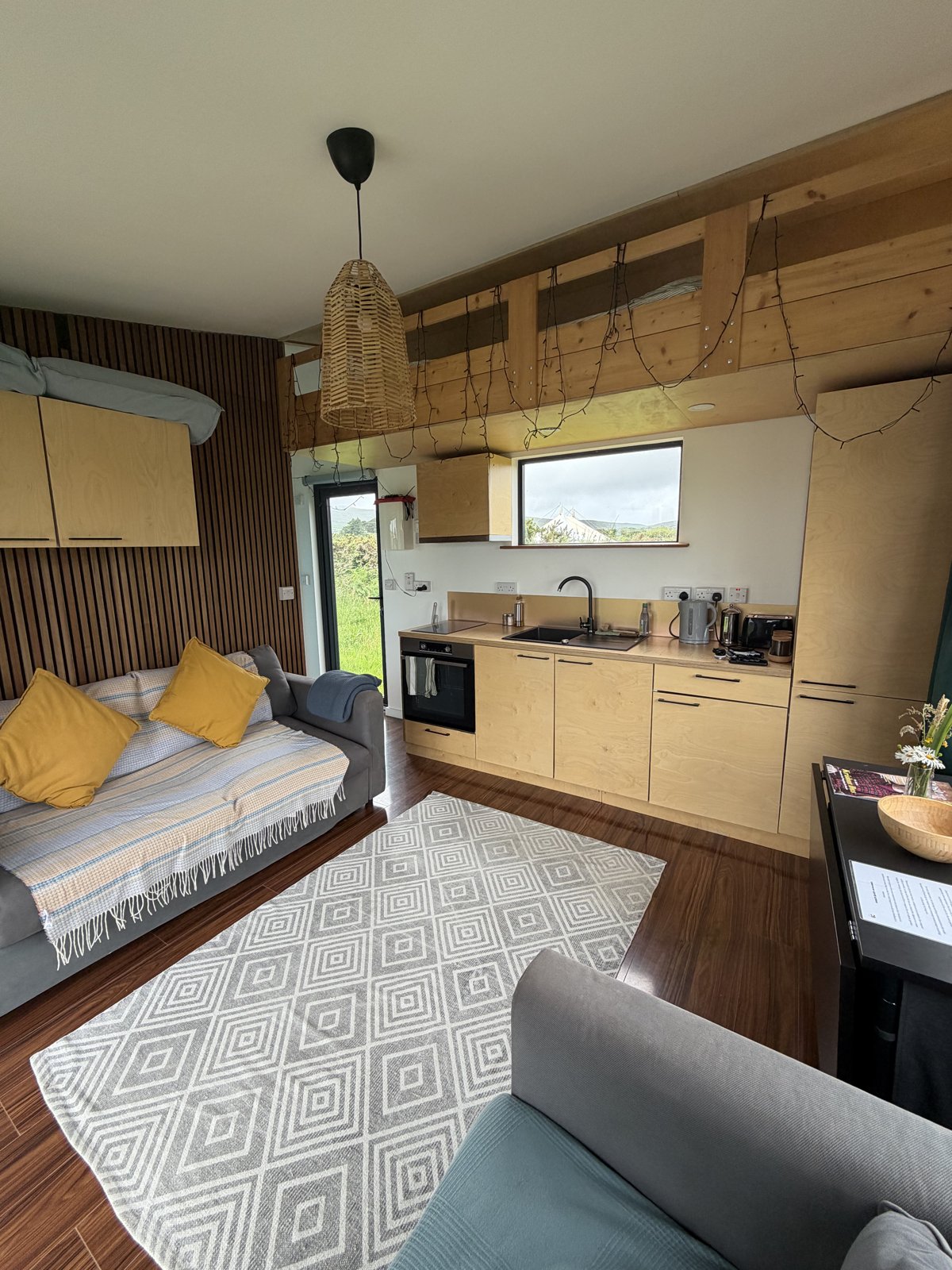 The bright open-plan living room and kitchen of the eco cabin
