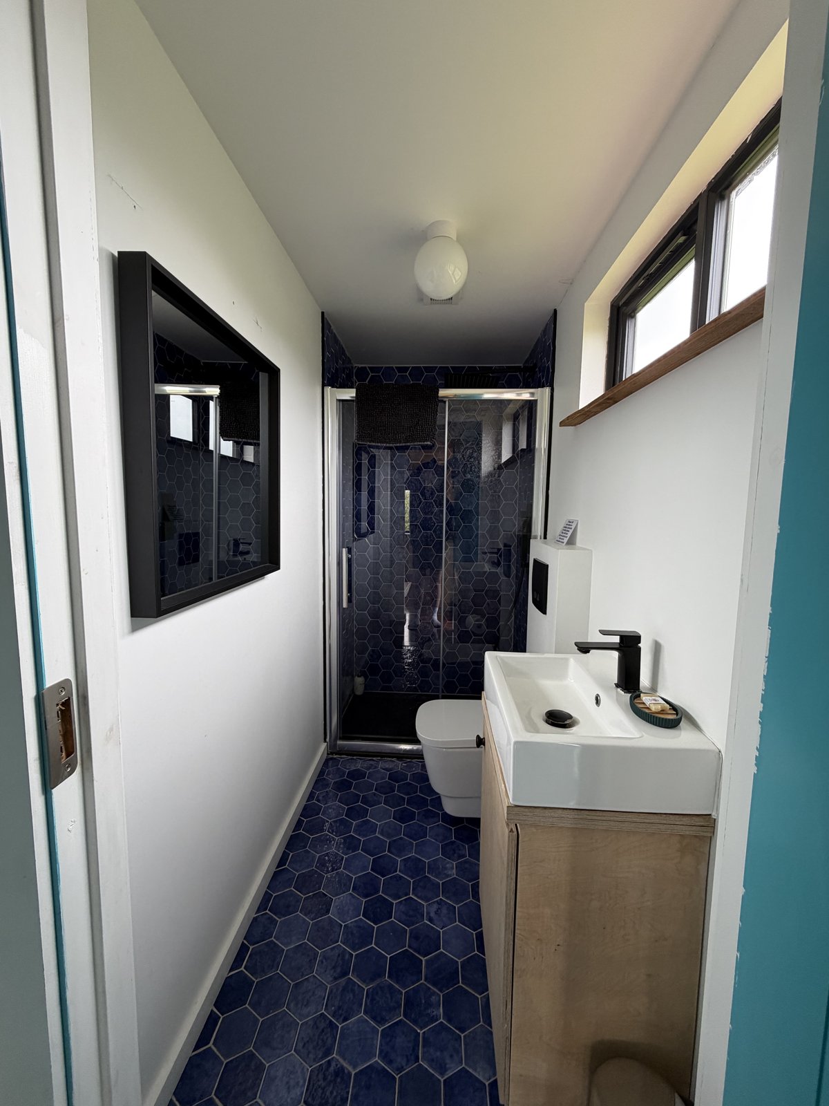 The cabin's blue-tiled bathroom with a walk-in shower