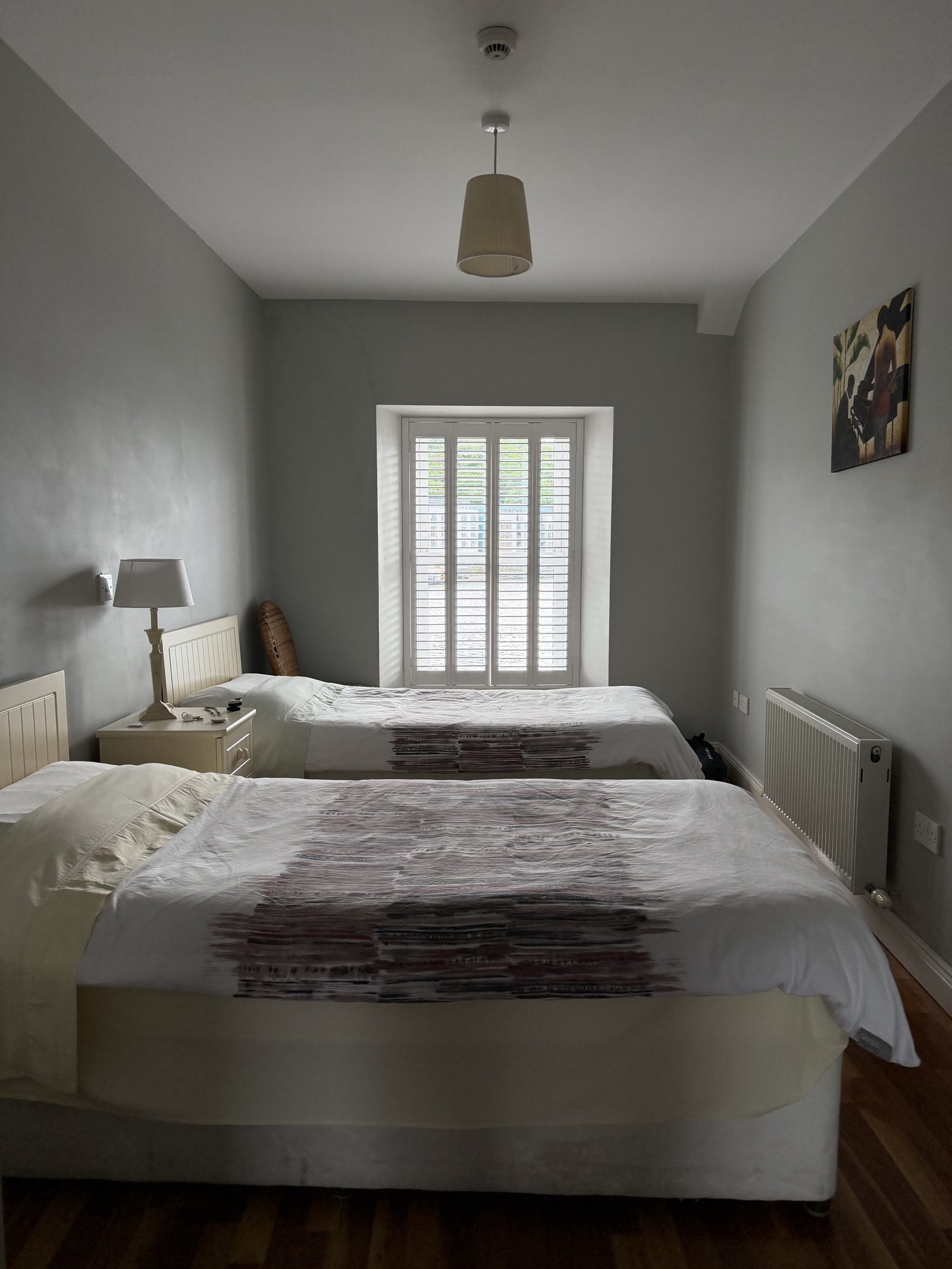 The B&B bedroom with two neatly made beds and a shuttered window