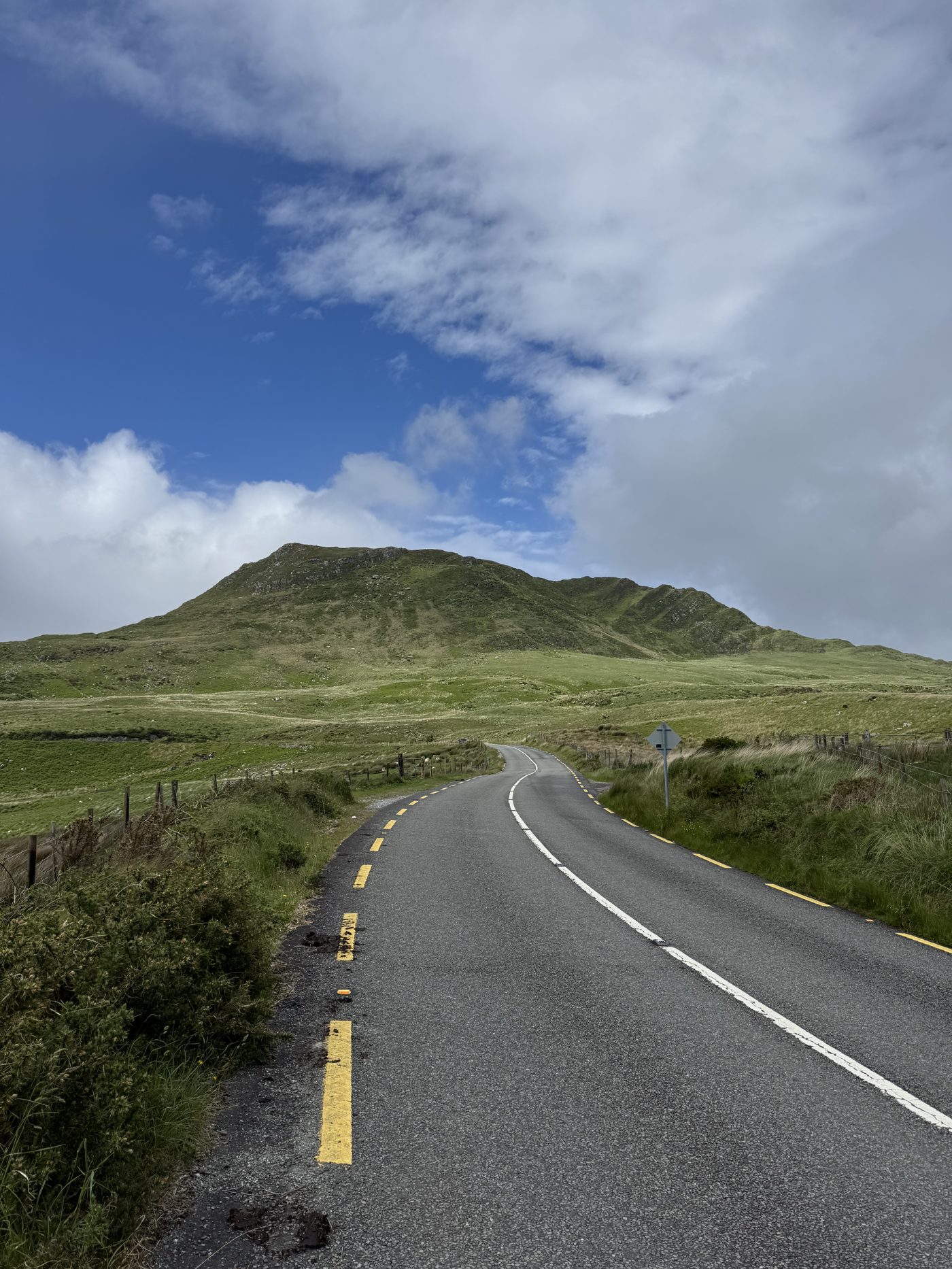 Open road climbing toward a Kerry mountain on day five