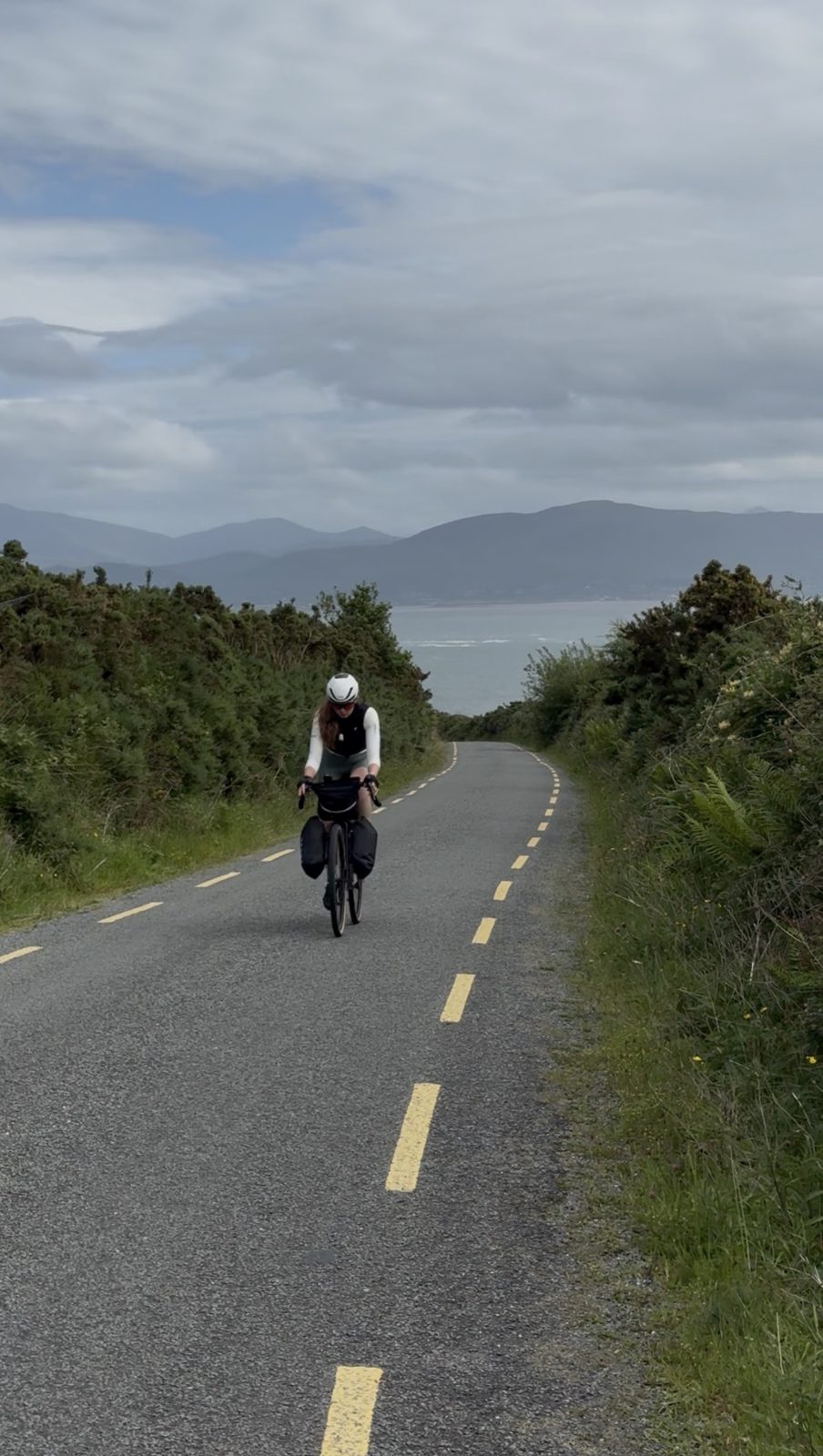 A rider on the greenway heading toward the mountains with Dingle Bay opening out ahead