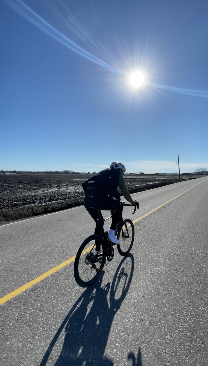 Rider crossing the Holland Marsh under a bright sun on the Tour de Holland